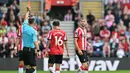 Wasit memberikan kartu merah kepada pemain Southampton, Jack Stephens (kanan) pada laga lanjutan Liga Inggris 2023/2024 melawan Manchester United di St Mary's Stadium, Southampton, Inggris, Sabtu (14/09/2024). (AFP/Glyn Kirk)