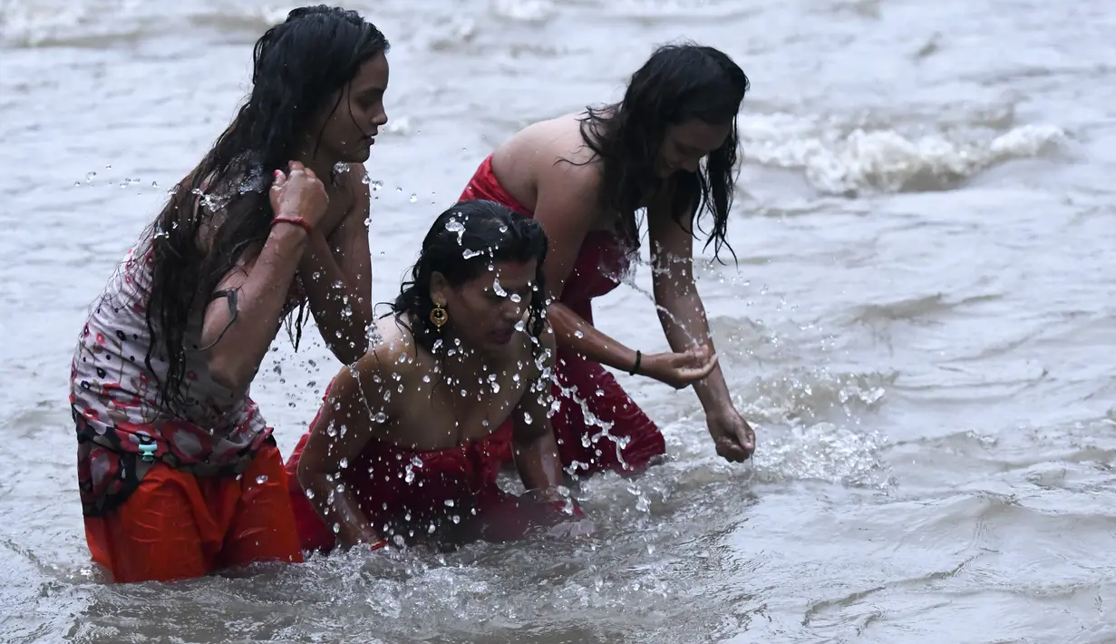 Tiga wanita Hindu Nepal mandi suci di sungai Bagmati selama festival Rishi Panchami di Kathmandu (3/9/2019). Rishi Panchami menandai berakhirnya Festival Teej selama tiga hari, dirayakan di Nepal dan beberapa bagian India oleh wanita Hindu yang sudah menikah. (AFP Photo/Prakash Mathema)