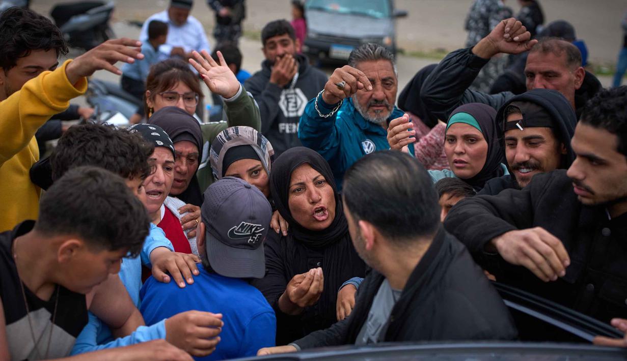 Unit Manajemen Risiko Bencana Lebanon, pada 26-27 Maret 2026, melaporkan, ada sekitar 136.262 orang yang mencakup 34.973 keluarga berada di berbagai pusat penampungan resmi. Tampak dalam foto, para pengungsi yang melarikan diri dari serangan artileri Israel di Lebanon selatan berjuang meraih kantong-kantong makanan saat pembagian di samping tenda-tenda yang digunakan sebagai tempat penampungan di Beirut, Lebanon, Rabu, 1 April 2026. (AP Photo/Emilio Morenatti)