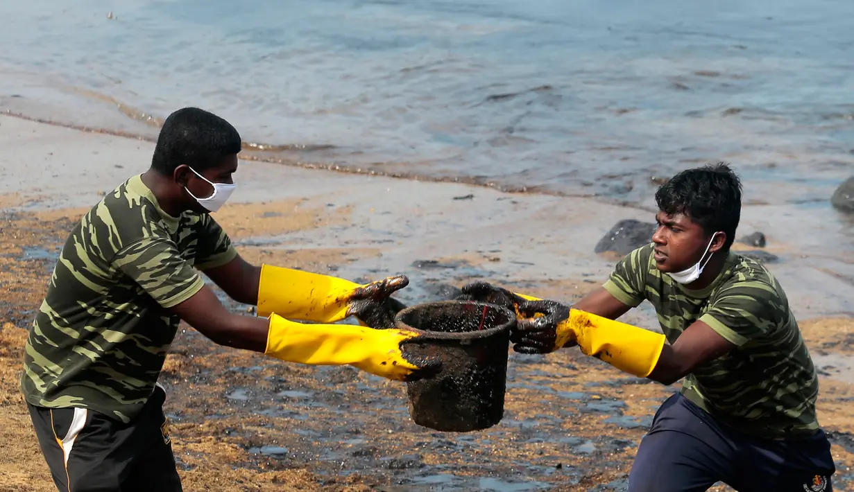 Tentara Sri Lanka bahu membahu membersihkan tumpahan minyak di sebuah pantai di Uswetakeiyawa, Kolombo, Senin (10/9). Meski kebocoran telah berhenti, butuh dua atau tiga hari untuk menyelesaikan pembersihan. (AP Photo/Eranga Jayawardena)