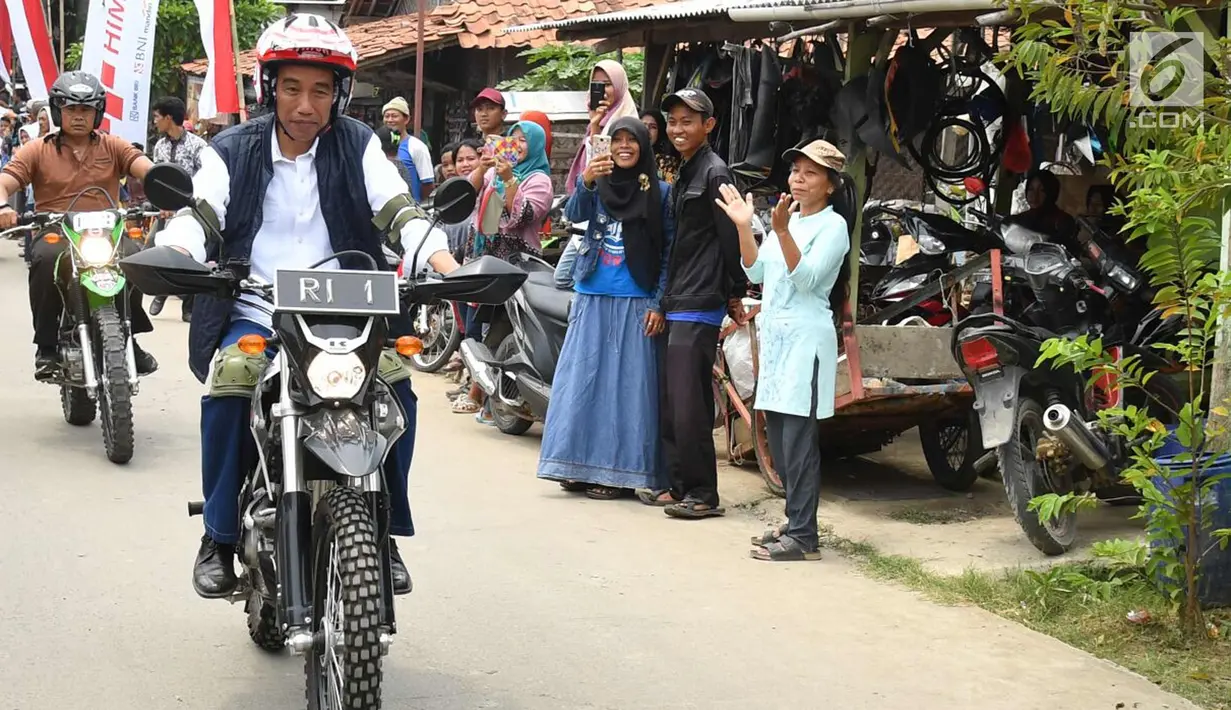 Presiden Joko Widodo mengendarai motor trail melintasi perkampungan di Muara Gembong, Bekasi (1/11). Jokowi menghadiri kegiatan Perhutanan Sosial untuk Pemerataan Ekonomi. (Liputan6.com/Biro Pers Kepresidenan/Agus Suparto)