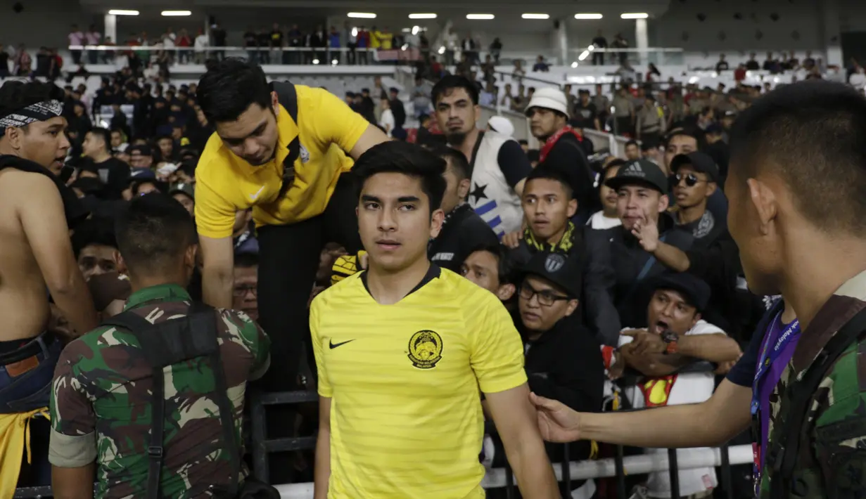 Menpora Malaysia, Syed Saddiq Syed Abdul Rahman, harus dievakuasi akibat kerusuhan saat sedang menonton laga Kualifikasi Piala Dunia 2022 melawan Timnas Indonesia. (Bola.com/Vitalis Yogi Trisna)