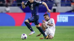 Pemain Timnas Indonesia, Yance Sayuri (kanan) berusaha merebut bola dari pemain Jepang, Kota Tawaratsumida dalam laga terakhir putaran ketiga Grup C Kualifikasi Piala Dunia 2026 di Suita Stadium, Jepang, Selasa (10/06/2025). (AFP/Paul Miller)