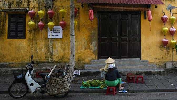 Gambar pada 14 September 2019 memperlihatkan pedagang buah yang ada di kota tua Hoi An, Vietnam. Kota Tua Hoi An merupakan destinasi wisata yang cukup populer di Vietnam, didukung oleh statusnya sebagai salah satu Unesco World Heritage Site. (Manan VATSYAYANA/AFP)