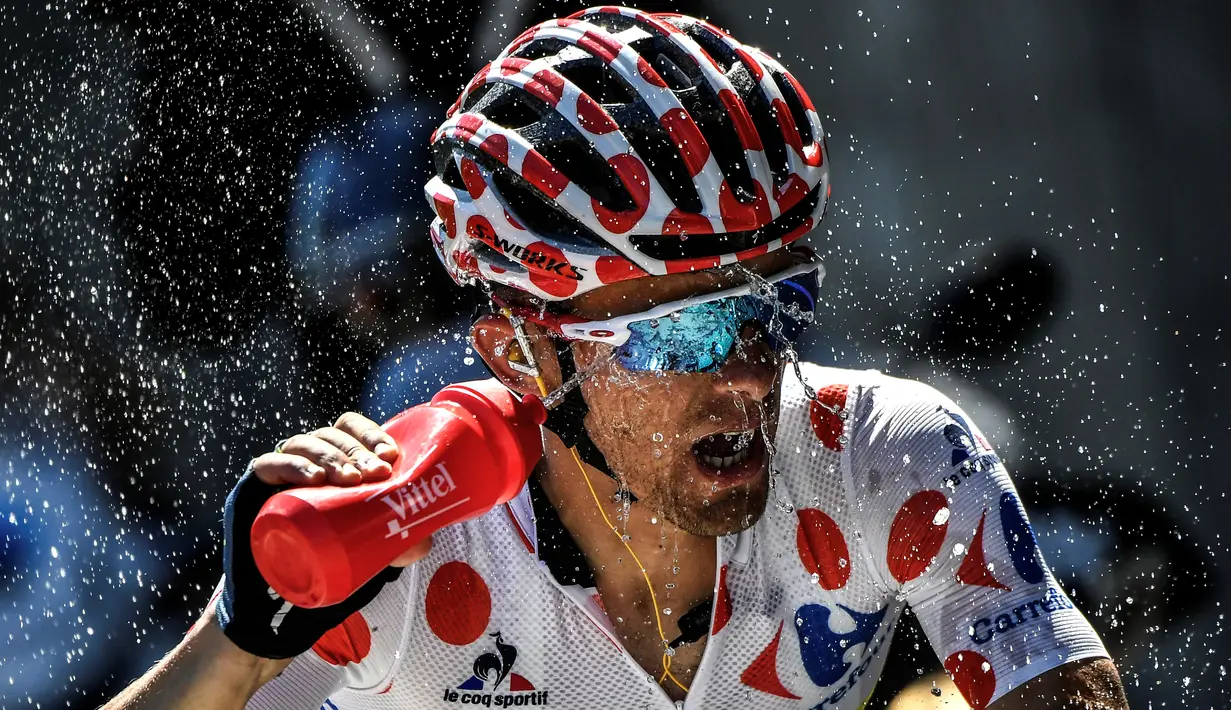 Pemegang kaus polkadot asal Polandia, Rafal Majka, menyemprotkan air ke wajahnya saat beraksi dalam Etape 17 Tour de France berjarak 184,5 km antara Berne dan Finhaut-Emosson, Prancis (20/7/2016). (AFP/Jeff Pachoud)