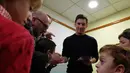 Bintang Barcelona, Lionel Messi melayani permintaan tanda tangan para pasien anak-anak saat melakukan kunjungan amal di Rumah Sakit Barcelona, Senin (4/1/2016). (AFP PHOTO / Lluis GENE)