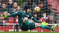 Kiper Arsenal Arsenal, Petr Cech berhasil mengagalkan tendangan pemain  Watford pada lanjutan pertandingan Liga Inggris di Emirates Stadium, Minggu (11/3). Arsenal sukses mengandaskan Watford dengan skor menyakinkan 3-0. (Ben STANSALL / AFP)