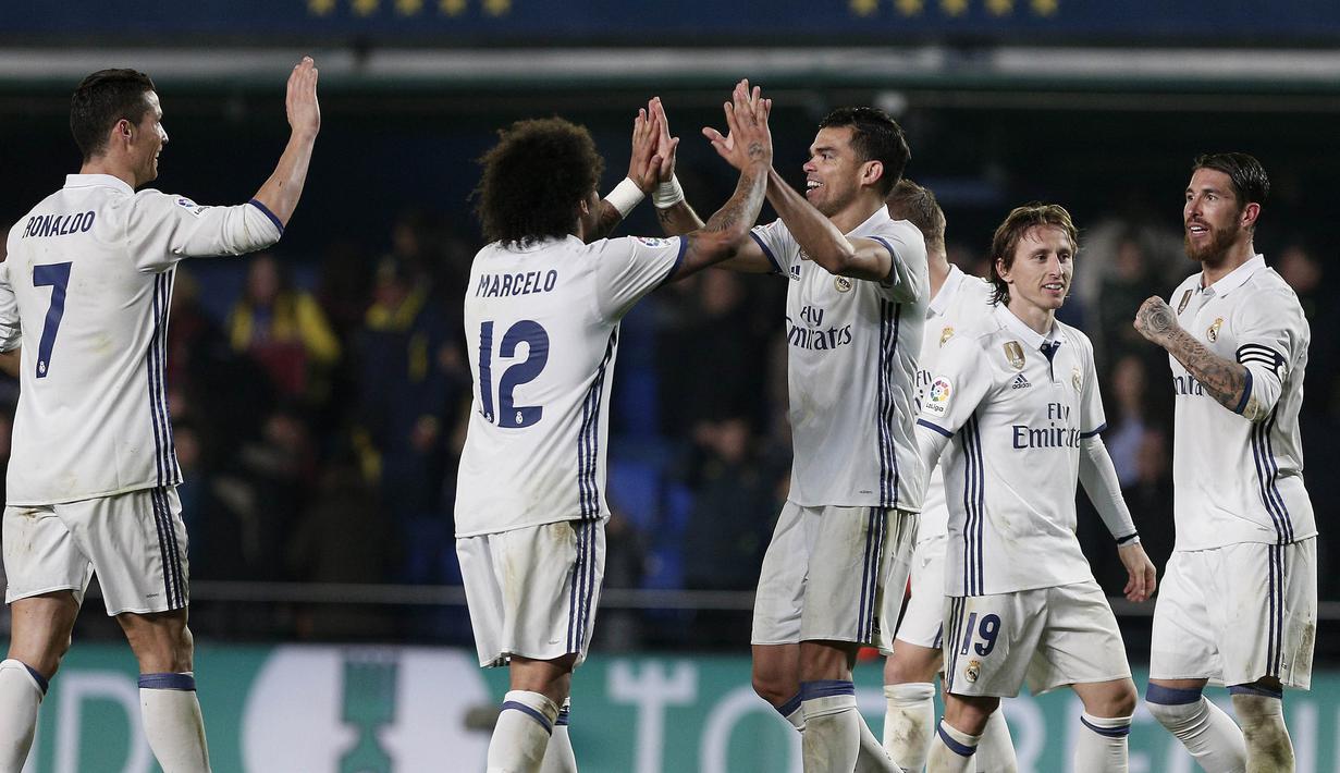 Para pemain Real Madrid merayakan keberhasilan menaklukkan Villarreal. Kemenangan ini membuat Real Madrid tetap memimpin klasemen Liga Spanyol, sedangkan Villarreal tertahan pada posisi keenam. (EPA/Miguel Angel Pozo)