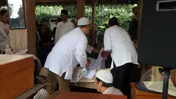 Sejumlah kerabat tampak mengkafani jenazah Didi Petet di musala di rumah kediaman almarhum di kawasan ciputat, Tangerang Selatan, Jumat (15/5/2015). Didi Petet meninggal di usia 58 tahun karena diduga menderita asam lambung. (Liputan6.com/Helmi Afandi)