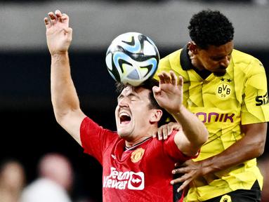 Bek Manchester United, Harry Maguire, duel udara dengan pemain Borussia Dortmund, Sebastien Haller, dalam laga uji coba pramusim yang digelar di Allegiant Stadium, Las Vegas, Senin (31/7/2023). MU takluk 2-3 dari Dortmund. (Photo by Patrick T. Fallon / AFP)