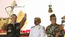 Presiden Joko Widodo (Jokowi) memainkan wayang kulit disaksikan dalang Ki Mantep Sudarsono (tengah) dalam Pagelaran Wayang Kulit 74 Tahun Indonesia Merdeka di halaman depan Istana Merdeka, Jakarta, Jumat (2/8/2019). Pagelaran wayang mengangkat tema "Kresno Jumeneng Ratu”.(Liputan6.com/Angga Yuniar)