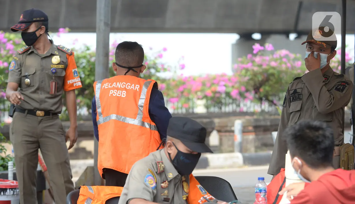 Petugas Satpol PP memberikan sanksi sosial kepada warga pelanggar karena tidak menggunakan masker saat melintas di Lebak Bulus, Jakarta, senin (14/9/2020). Pemerintah Provinsi DKI Jakarta memperketat kembali PSBB karena kasus Covid-19 terus mengalami peningkatan. (merdeka.com/Dwi Narwoko)