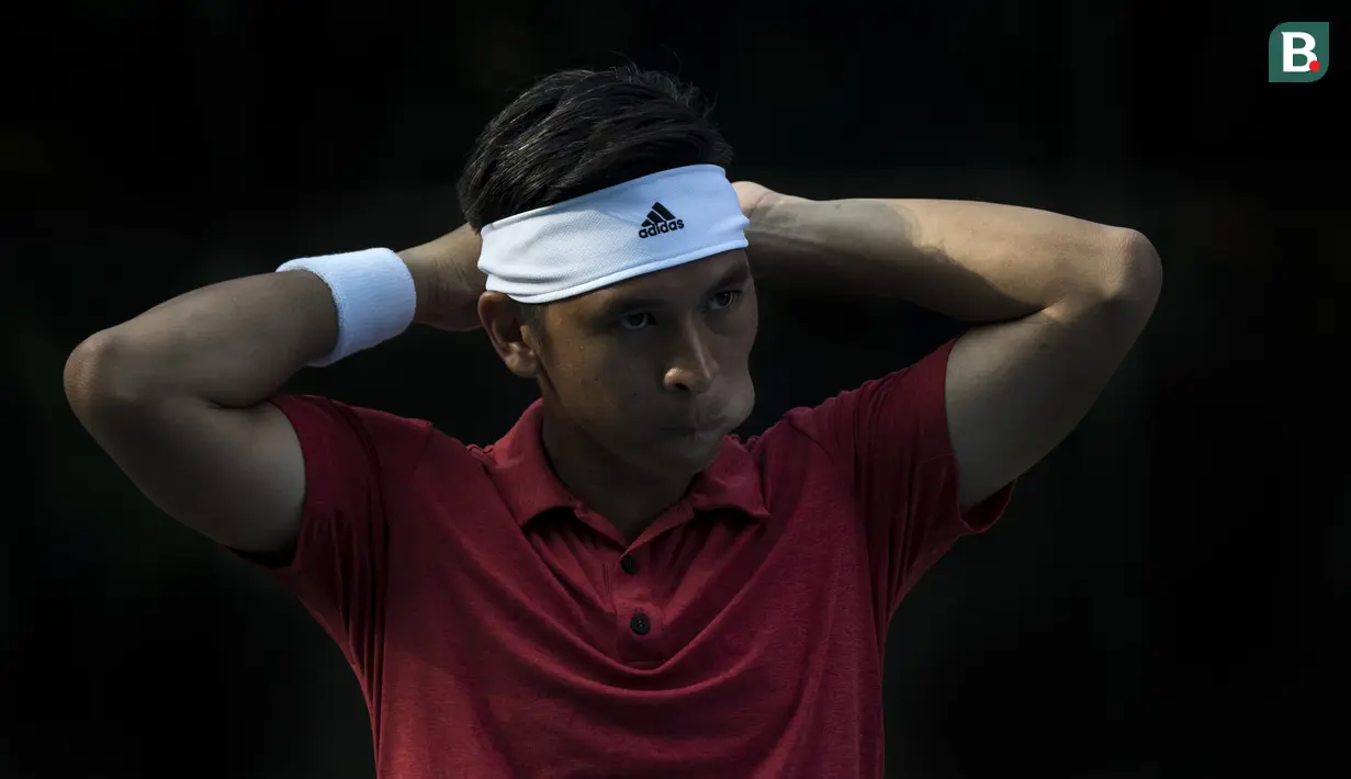 Petenis Indonesia, Christopher Rungkat, memasang ikat kepala saat latihan di Lapangan Tenis Pondok Indah, Jakarta, Kamis (19/7/2018). Dirinya merupakan salah satu petenis yang akan turun pada Asian Games XVIII. (Bola.com/Vitalis Yogi Trisna)