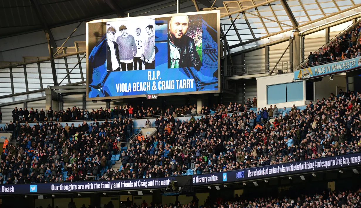 Sebuah layar menampilkan foto para anggota band  Viola Beach dan manajer mereka menjelang laga Manchester City dan Tottenham Hotspur di Inggris, Minggu (14/2). Empat personel band asal Inggris itu tewas dalam kecelakaan mobil di Swedia. (Oli SCARFF/AFP)