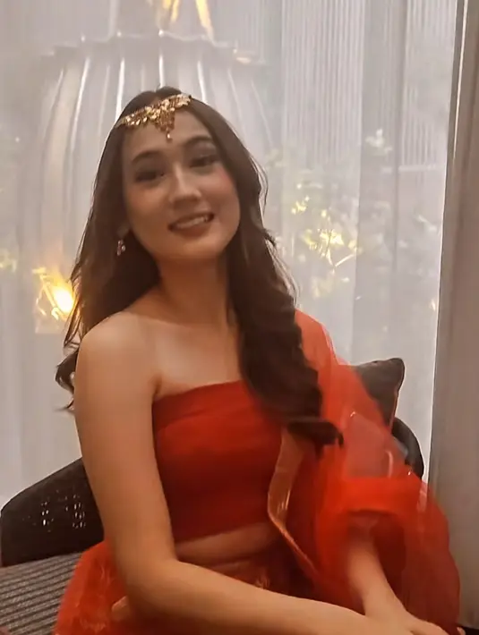 Laura Moane mengenakan sari warna merah dengan rambut panjang yang digerai tanpa poni. [@kainsarijakarta]