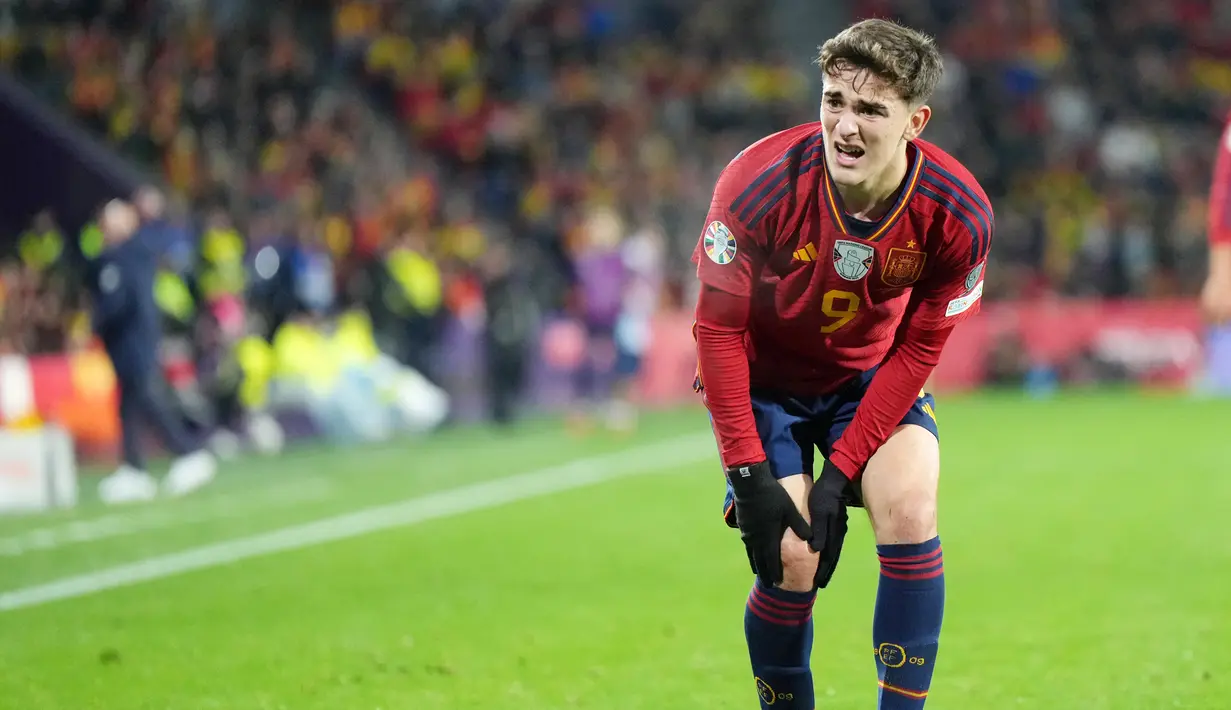 Pemain Spanyol, Gavi, meringis kesakitan karena mengalami cedera lutut saat melawan Georgia pada kualifikasi Euro 2024 Grup A di Stadion Jose Zorrilla, Valladolid, Spanyol, Senin (20/11/2023). Menurut laporan media Spanyol, pemain Barcelona tersebut mengalami cedera ACL. (AFP/Cesar Manso)