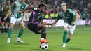 Penyerang Bayern Munchen, Kingsley Coman (Tengah) dan bek Werder Bremen, Mitchell Weiser (kanan) berebut bola dalam laga pekan ke-1 Bundesliga 2023/2024 di Stadion Wesser, Sabtu (19/8/2023) dinihari WIB. (Photo by Focke Strangmann / AFP)