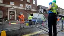 Pekerja memasang pagar pembatas di seberang area Lingdo Wing, Rumah Sakit St. Mary di Paddington, London, Senin (9/4). Rumah sakit tempat Kate Middleton direncanakan akan melahirkan mulai meningkatkan aktivitas pengamanannya. (AP/Kirsty Wigglesworth)