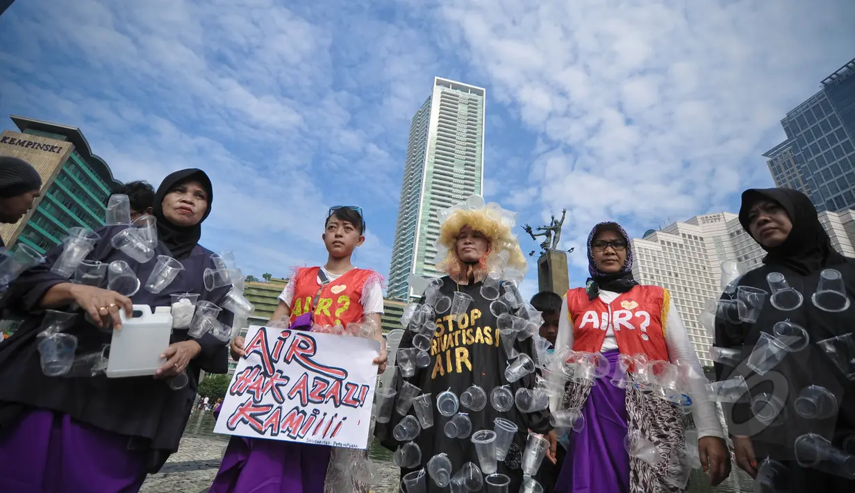 Sejumlah aktivis mengenakan kostum dari sampah plastik air mineral saat menggelar aksi Menolak Swastanisasi Air Jakarta di Bundaran HI, Jakarta, Minggu (22/3/2015). (Liputan6.com/Faizal Fanani)