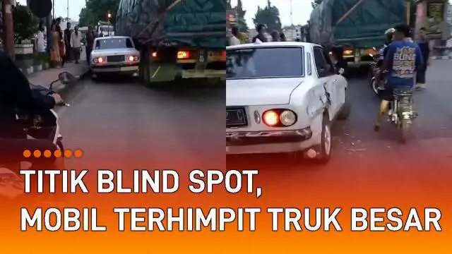 Sebuah mobil terhimpit truk besar di jalan mengundang perhatian