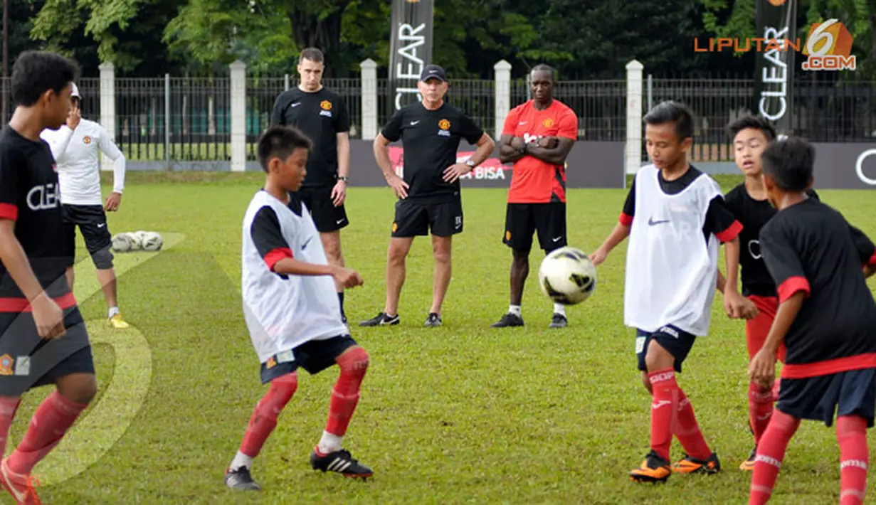 Dwight Yorke dan pelatih Manchester United Soccer Schools memperhatikan dengan serius anak-anak SSB Asiop Apacinti yang mengikuti Training Camp Ayo Indonesia Bisa (Liputan6.com/Helmi Fithriansyah)