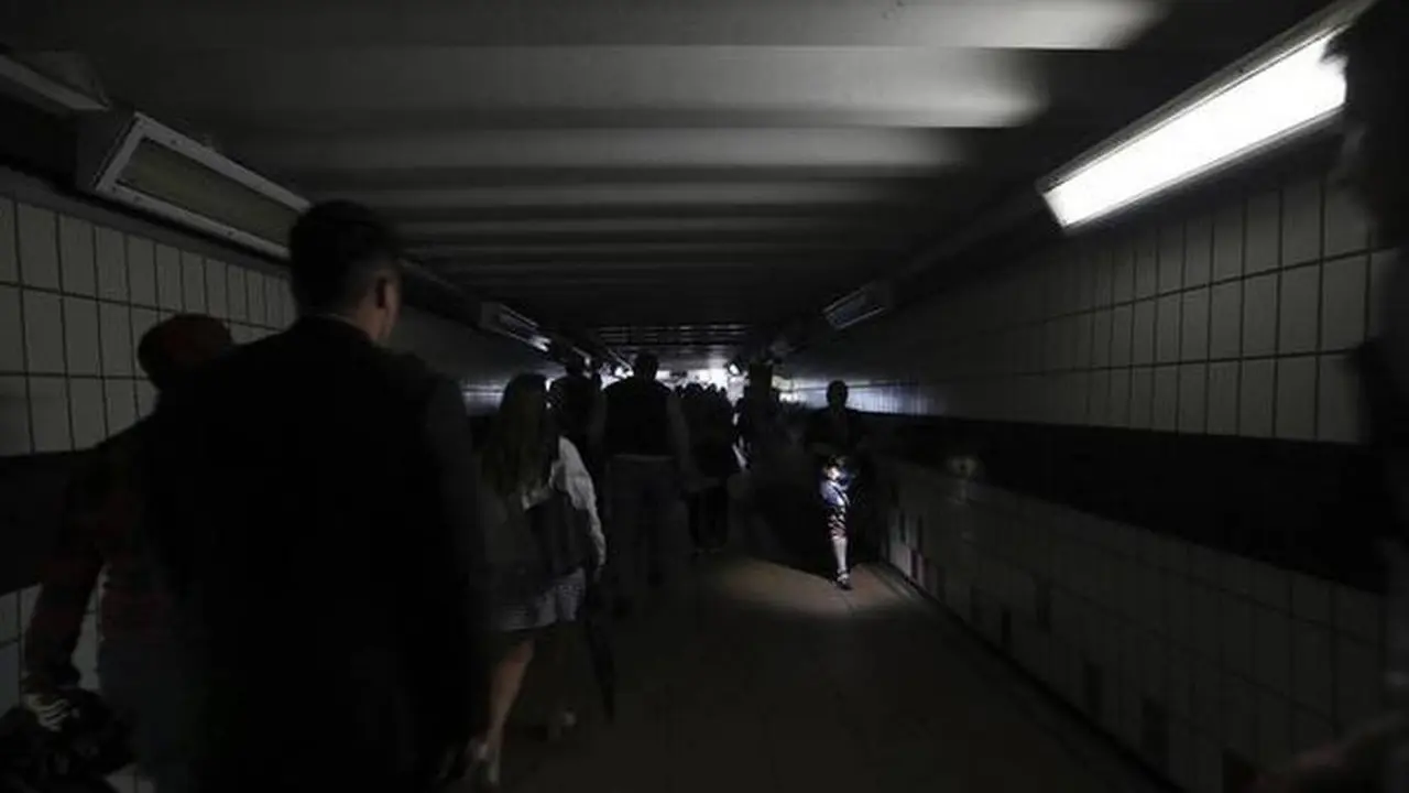 Orang-orang berjalan di kegelapan Stasiun Clapham Junction saat pemadaman listrik, di London pada 9 Agustus 2019. (AP)