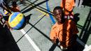 Seorang anak mencoba melambungkan bola voli pada program Volleyball Development Training yang digagas oleh FIVB di Formiga favela, Rio de Janeiro, (2/8/2016). (AFP/Leon Neal)