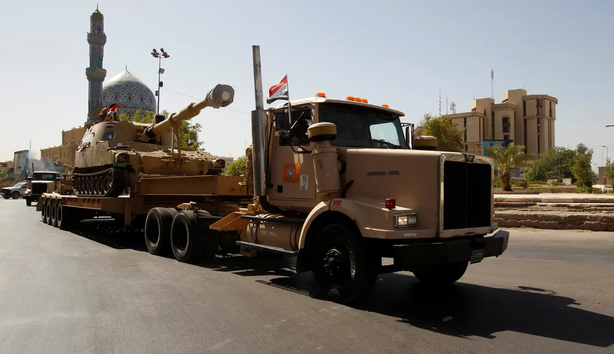 Pasukan keamanan Irak membawa sebuah tank saat mengambil bagian dalam parade militer di sepanjang jalan Kota Baghdad, Irak (12/7). Irak memamerkan kekuatan peralatan tempur unggulannya sebagai langkah lanjutan menggempur ISIS. (REUTERS/Khalid al Mousily)