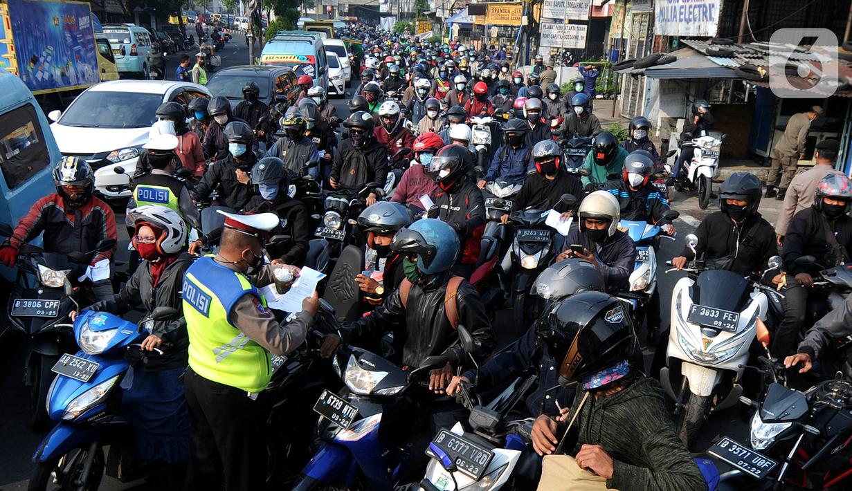 Petugas polisi memeriksa kelengkapan Surat Tanda Registrasi Pekerja  (STRP) bagi pengendara bermotor pada pos  perpanjangan Pemberlakuan Pembatasan Kegiatan Masyarakat (PPKM) Jalan Raya Ir.H.Djuanda, depan Sandratex, Tangerang Selatan, Kamis (15/07/2021). (merdeka.com/Arie Basuki)