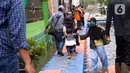 Warga berjalan melintasi jembatan apung saat banjir melanda Perumahan Periuk Damai, Tangerang, Banten, Selasa (23/2/2021). Adanya jembatan apung mempermudah warga saat melintasi banjir setinggi 2,5 meter di tempat tersebut. (Liputan6.com/Angga Yuniar)