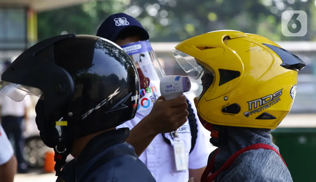 Petugas mengecek suhu pengunjung sebelum memasuki Taman Margasatwa Ragunan, Jakarta, Sabtu (20/6/2020). Ragunan mulai dibuka kembali untuk pengunjung di Sabtu ini pada masa PSBB transisi dengan pembatasan dan penerapan protokol kesehatan yang ketat. (Liputan6.com/Herman Zakharia)