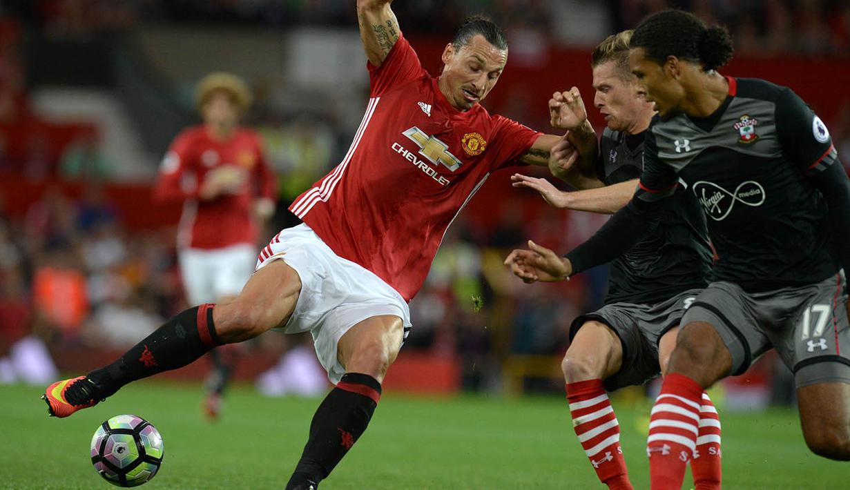 Striker Manchester United, Zlatan Ibrahimovic, berusaha melewati gelandang Southampton, Steven Davis. Gol pertama MU dicetak oleh Ibra pada menit ke-36 melalui umpan dari Wayne Rooney. (AFP/Oli Scarff)