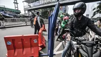 Pengendara melintasi penyekatan mobilitas di Jalan Basuki Rahmat, Jakarta Timur, Kamis (15/7/2021). Kendaraan yang diperbolehkan melintas hanya yang bekerja di sektor esensial dan kritikal serta pengendara yang memiliki Surat Tanda Registrasi Pekerja (STRP). (merdeka.com/Iqbal S Nugroho)