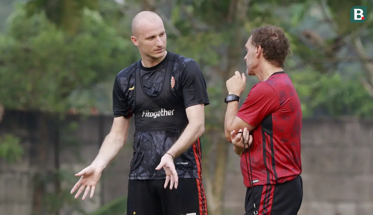 Pelatih Persija Jakarta, Thomas Doll, berbincang dengan Michael Krmenčík saat sesi latihan di Nirwana Park Sawangan, Jawa Barat, Kamis (7/7/2022). Latihan merupakan persiapan jelang bergulirnya Liga 1 musim 2022/2023. (Bola.com/M Iqbal Ichsan)