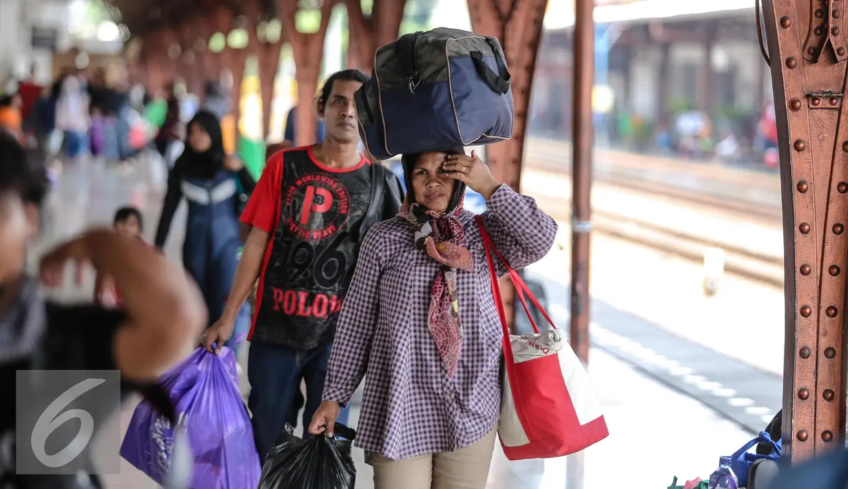 Seorang pemudik tampak membawa tas di atas kepalanya, Jakarta, Kamis (16/7/2015). Memasuki H-1 Lebaran, Stasiun Pasar Senen memberangkatkan sebanyak 8.443 pemudik. (Liputan6.com/Faizal Fanani)