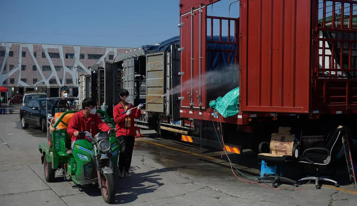 Para staf mendisinfeksi sejumlah kendaraan yang terparkir di pasar Xinfadi di Distrik Fengtai di Beijing, ibu kota China, pada 7 Juli 2020. Kelompok pertama yang terdiri dari 5.000 orang lebih akan diizinkan pulang dengan tertib, menurut otoritas Distrik Fengtai. (Xinhua/Peng Ziyang)