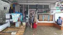 Aktivitas warga saat banjir merendam RW 06 kawasan Mekarsari, Depok, Jawa Barat, Sabtu (20/2/2021). Banjir yang disebabkan meluapnya aliran Kali Cipinang Timur ini terjadi akibat intensitas hujan tinggi di wilayah tersebut (Liputan6.com/Herman Zakharia)