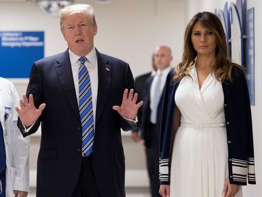 Presiden AS Donald Trump (tengah) didampingi istrinya Melania Trump (kanan) dan dokter Igor Nichiporenko (kiri) saat mengunjungi rumah sakit Broward Health North Pompano Beach, Florida (16/2). (AFP Photo/Jim Watson)