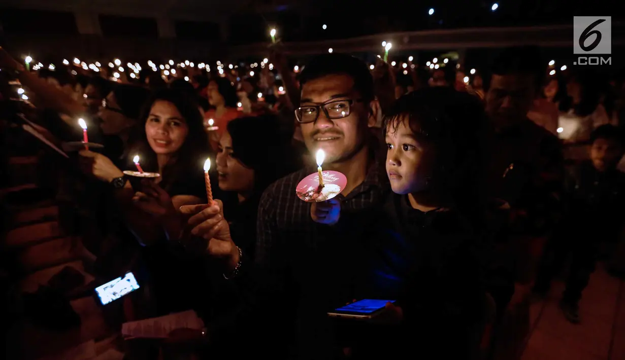 Jemaat menyalakan lilin dalam acara Natal Taruna Merah Putih di Jakarta, Jumat (22/12). Perayaan natal tersebut sebagai bentuk kepedulian terhadap kedaulatan Palestina. (Liputan6.com/Faizal Fanani)