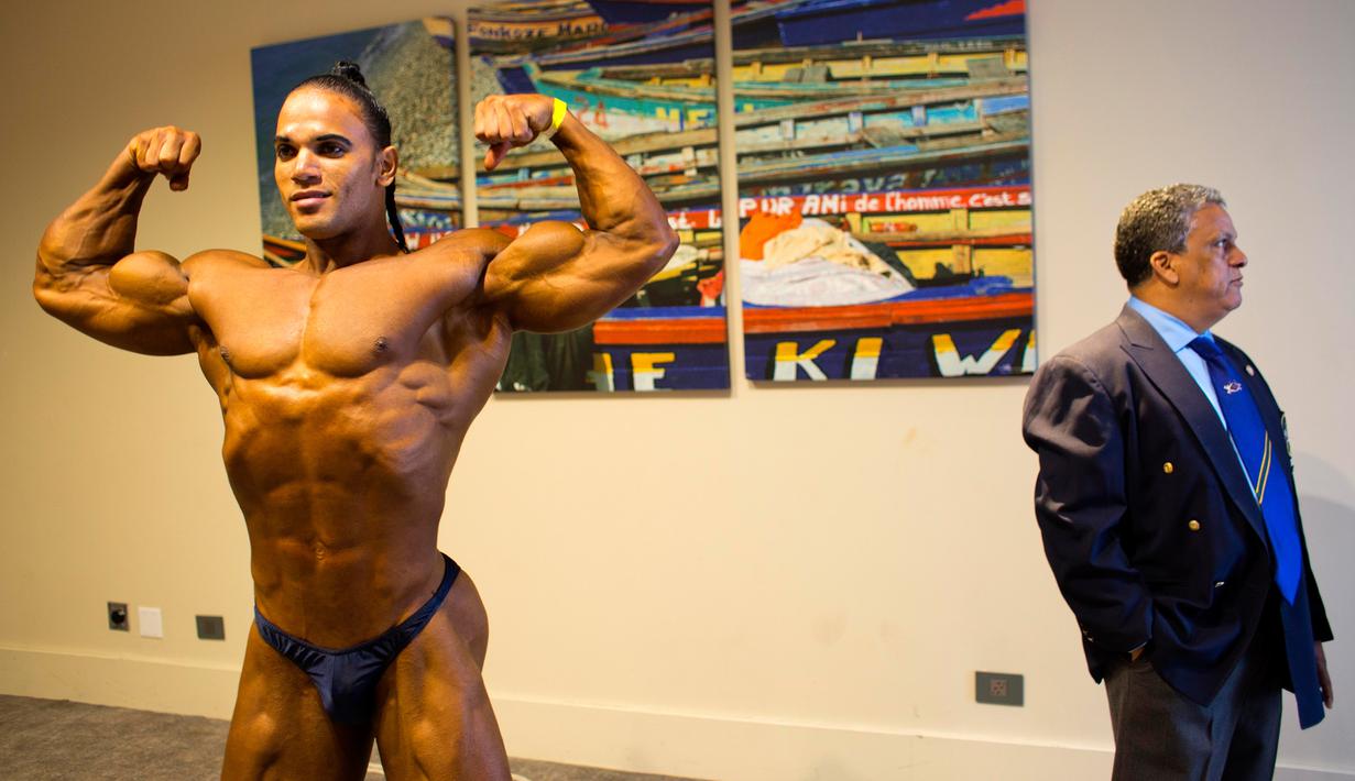 Binaragawan asal Dominika Jose Solano (kiri) berpose saat berkompetisi di Port-au-Prince, Haiti, Minggu (23/7). Kompetisi ini diikuti oleh binaragawan  antar dua negara, yaitu Haiti dan Republik Dominika. (AP/Dieu Nalio Chery)