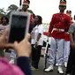 Warga berfoto bersama anggota Paspampres yang melakukan prosesi pergantian jaga Istana Kepresiden di depan Istana Merdeka, Minggu (28/8). Prosesi pergantian yang diwarnai sejumlah atraksi itu mengundang perhatian warga. (Liputan6.com/Faizal Fanani)