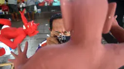 Seorang seniman menyelesaikan pembuatan patung atau yang dikenal ogoh-ogoh sebelum Perayaan Nyepi di Denpasar, Bali (12/3). Nyepi adalah hari raya umat Hindu yang dirayakan setiap tahun Baru Saka. (AFP Photo/Sonny Tumbelaka)