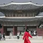 Seorang wanita mengenakan masker berjalan di Gerbang utama Istana Gyeongbok, Seoul, Korea Selatan, Sabtu (22/2/2020). Di Korea Selatan hingga kini sudah ada dua kematian akibat virus corona. (AP Photo/Lee Jin-man)