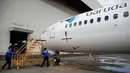 Teknisi membawa tangga saat akan memeriksa pesawat Boeing 737 Max 8 Garuda Indonesia di Bandara Soekarno Hatta, Tangerang, Rabu (13/3). Pemerintah menetapkan pelarangan permanen untuk pesawat Boeing 737 Max 8 terbang. (REUTERS/Willy Kurniawan)