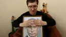 Seorang pengunjung menyentuh foto 3D Vladimir Putin di perpustakaan khusus tunanetra di Krasnoyarsk, Siberia, Rusia (15/3). Ini memudahkan warga yang tidak bisa melihat atau buta dapat mengenali sosok Putin. (REUTERS/Ilya Naymushin)