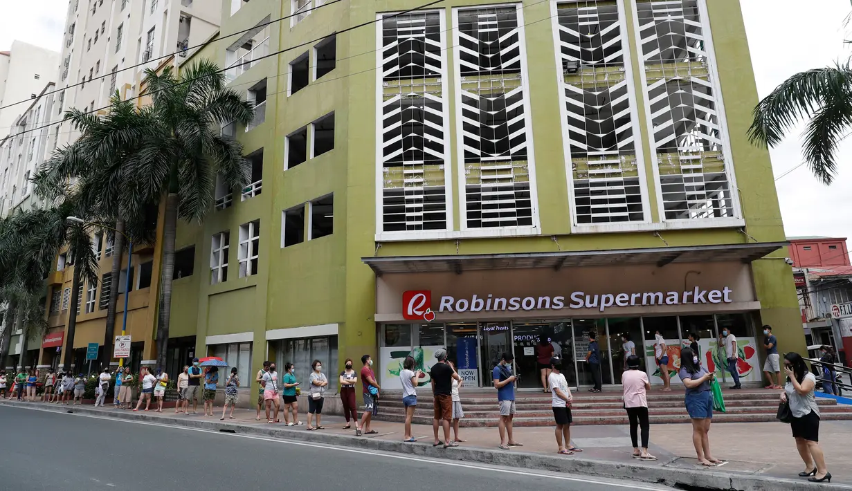 Warga menjaga jarak saat mengantre di luar supermarket di Manila, Filipina, Selasa (17/3/2020). Presiden Filipina, Rodrigo Duterte, memutuskan menutup akses keluar dan masuk Manila bagi seluruh jenis transportasi demi mencegah penyebaran virus corona Covid-19. (AP / Aaron Favila)
