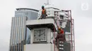 Petugas melakukan perawatan tugu jam yang berada di Merdeka Selatan, Jakarta, Minggu (2/2/2020). Perawatan tersebut dilakukan untuk pengecekan kondisi jam yang nantinya akan dipasangkan panel surya sebagai daya power agar tugu jam dapat berfungsi sebagai petunjuk waktu. (Liputan6.com/Angga Yuniar)