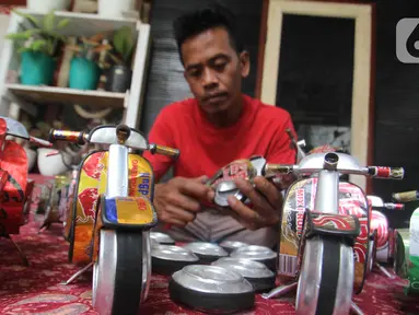 Perajin Ogifson Harianja, menyelesaikan miniatur vespa dari kaleng bekas, Jakarta, Jumat (7/1/2022). Pemerintah melalui Kemenko Perekonomian telah mengumumkan bahwa plafon penyaluran KUR 2022 ditingkatkan menjadi Rp373,17 triliun, dengan suku bunga tetap sebesar 6 persen. (Liputan6.com/Angga Yuniar)