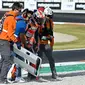 Pembalap Repsol Honda, Marc Marquez (tengah) mendapatkan bantuan tim medis setelah bersenggolan dengan pembalap Pramac Racing, Jorge Martin dalam MotoGP Valencia yang berlangsung di Sirkuit Ricardo Tormo, Valencia, Spanyol Minggu (26/11/2023). (AFP/Javier Soriano)