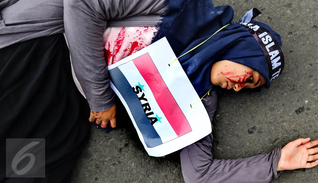Seorang demonstran dengan bendera Syria yang dikalungkan di leher melakukan aksi keprihatinan saat Car Free Day (CFD) di Bundaran HI, Jakarta (14/08). (Liputan6.com/Fery Pradolo).